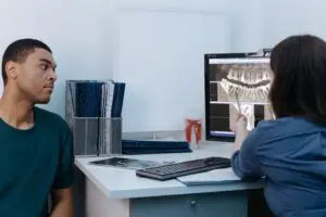 https://www.pexels.com/photo/a-man-having-a-dental-consultation-with-a-dentist-6502043/?utm Man consulting with dentist about dental work